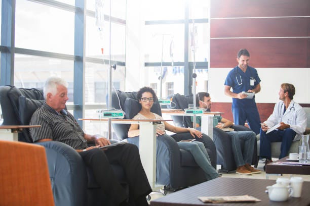 Patients undergoing medical treatment with doctors discussing in outpatient clinic  chemotherapy stock pictures, royalty-free photos & images