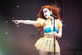 Chappel roan on stage in a short skirt and heavy eye akesup