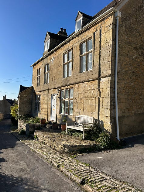 A row of stone built houses in Cottles Lane Turleigh climb up the hillside along the edge of the lane. Another image shows a large apple tree full of red apples. Photo: Roland Millward