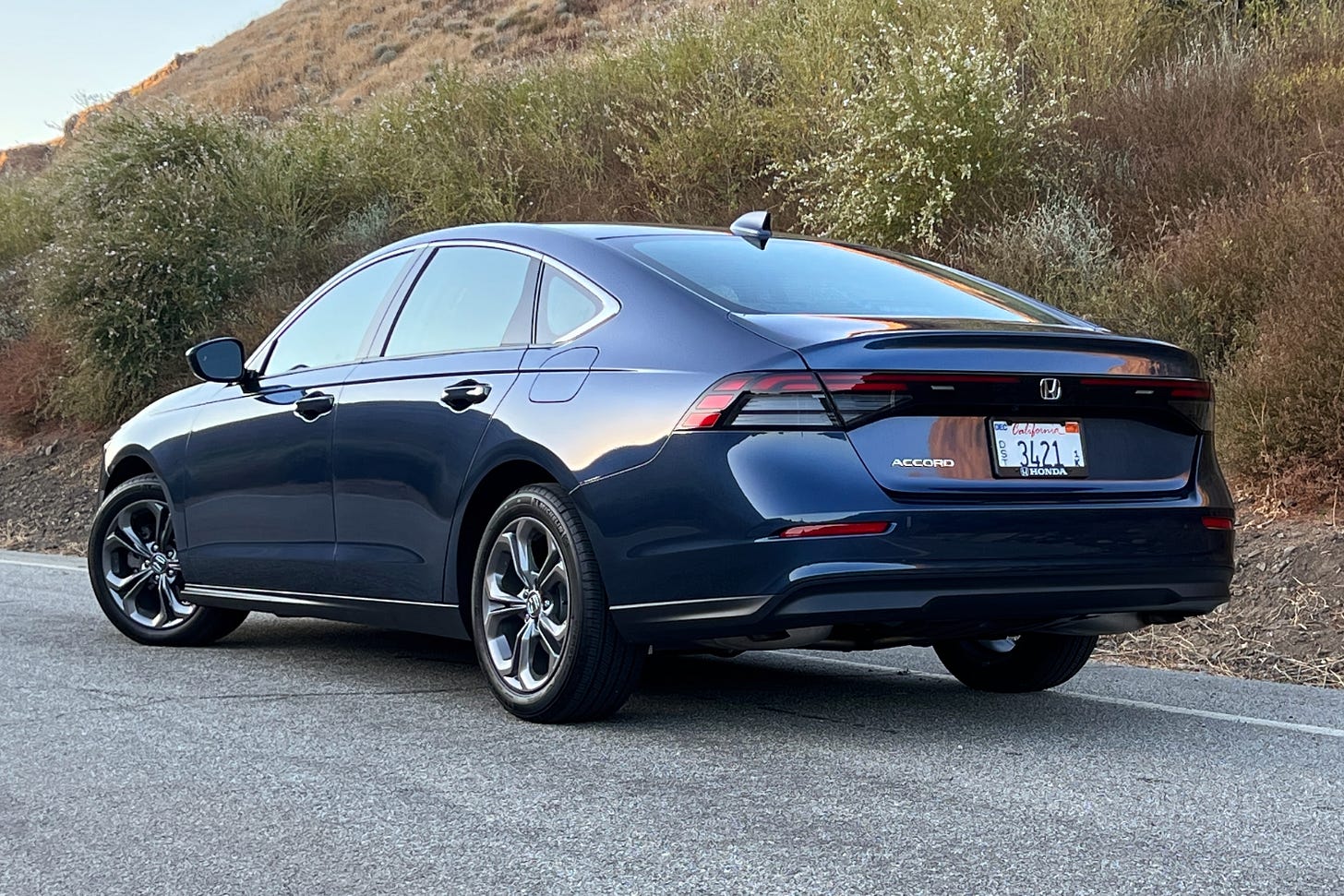 Rear view of a blue 2023 Honda Accord EX parked on the side of a road.