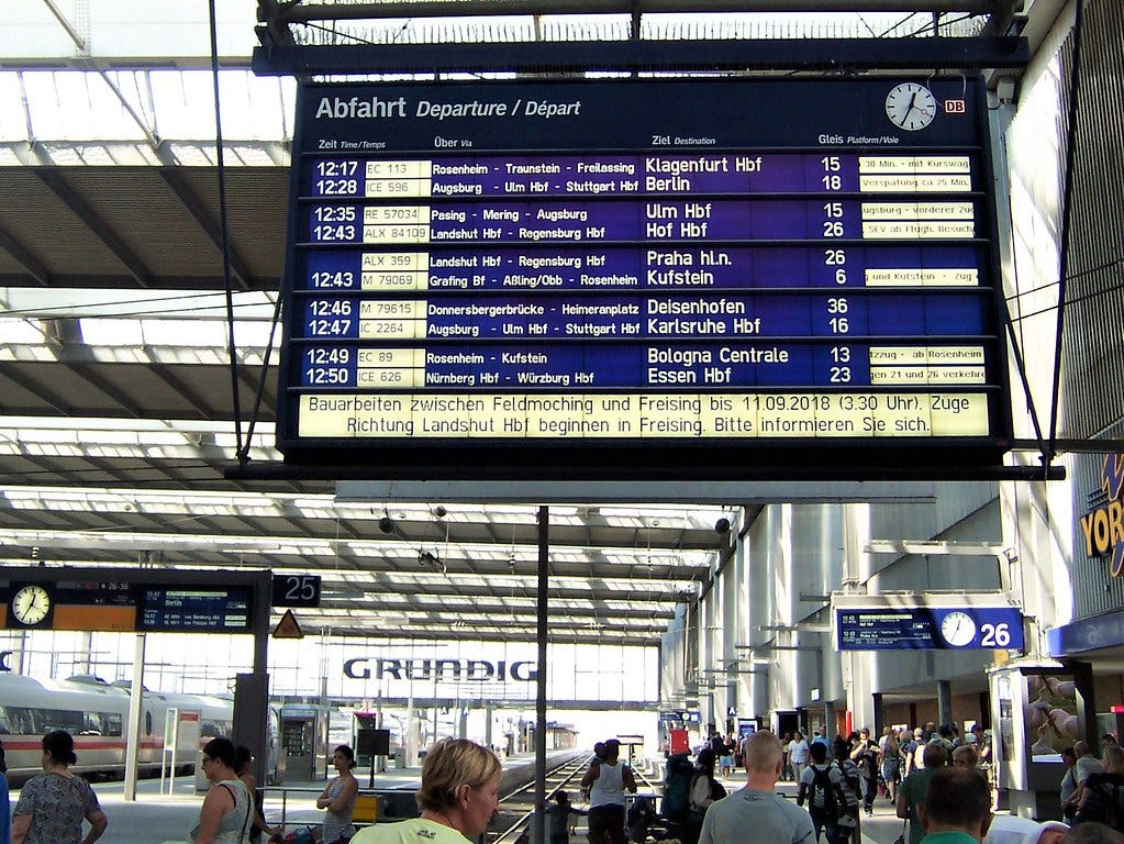 Image of a departure board at Munich station. From left to right, it shows: departure time, route identifier, key stations, the destination, the platform number, and additional service information. Image of a departure board at Munich station. From left to right, it shows: departure time, route identifier, key stations, the destination, the platform number, and additional service information.