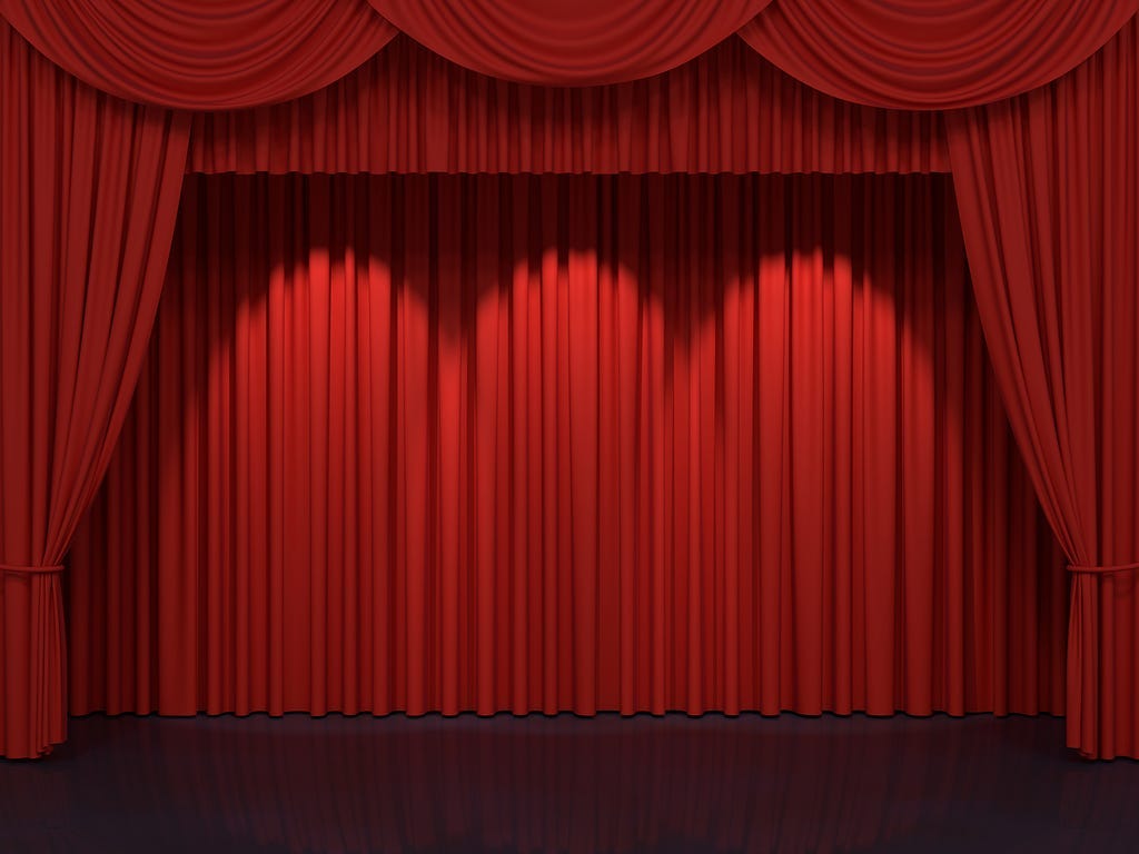 Red curtains framing an empty stage