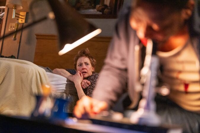 Carrie Coon cowers on a motel bed as Namir Smallwood looks through a microscope in Bug on Broadway
