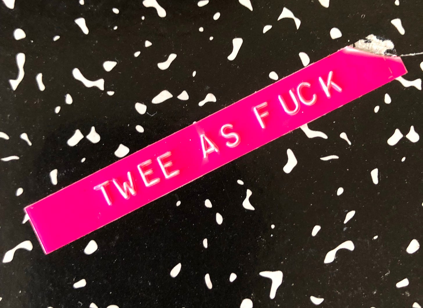 hot pink label maker tape reads "TWEE AS FUCK" on a black and white composition book background hot pink label maker tape reads "TWEE AS FUCK" on a black and white composition book background