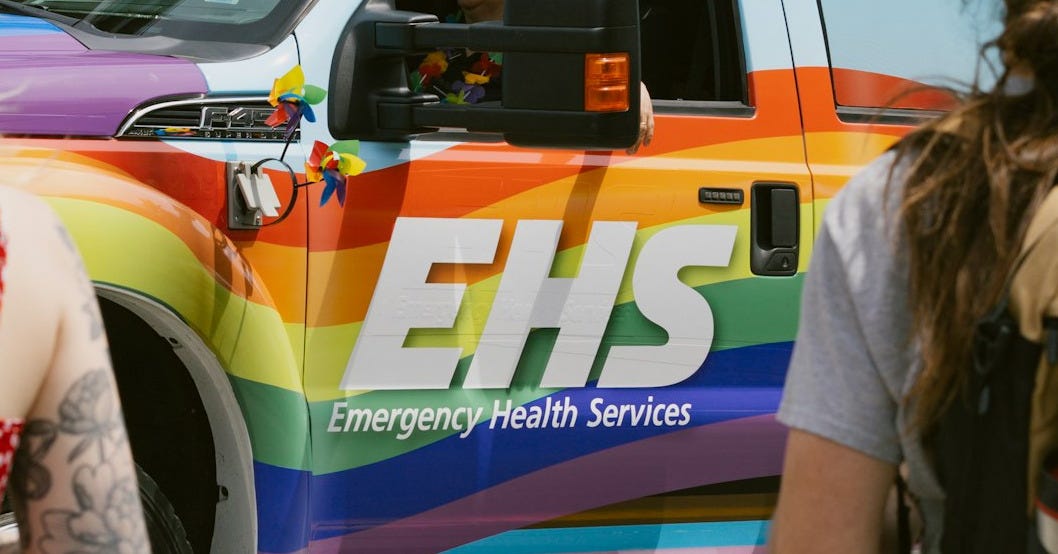 a truck with a rainbow stripe painted on the side of it a truck with a rainbow stripe painted on the side of it