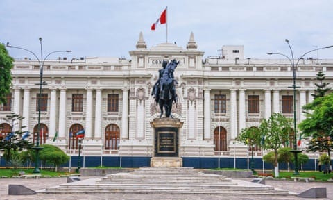 white building with dark grey statue in front of it white building with dark grey statue in front of it