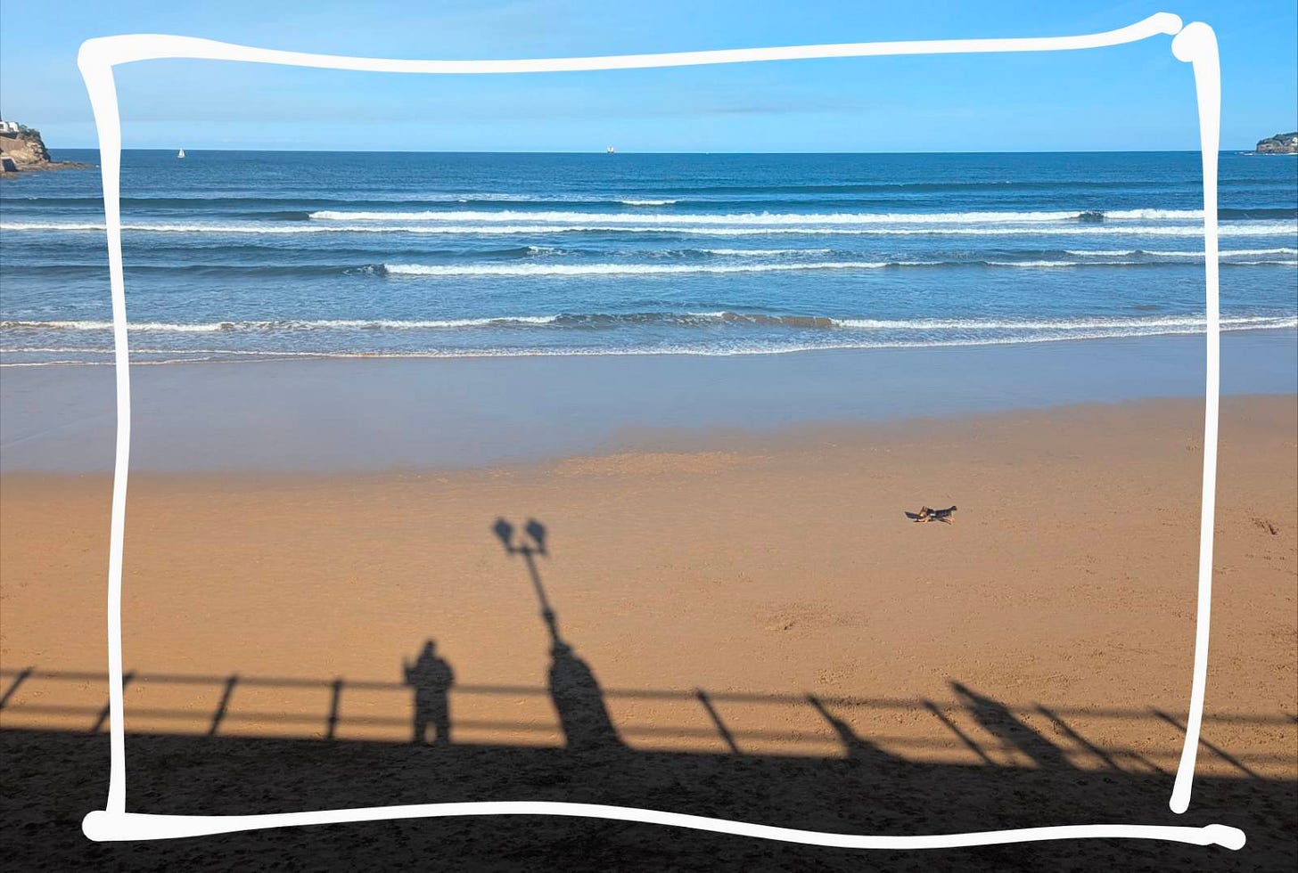una playa un día de sol. se ve mi sombra