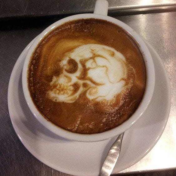 This may contain: there is a cup of coffee with a skull in the foamy liquid on it