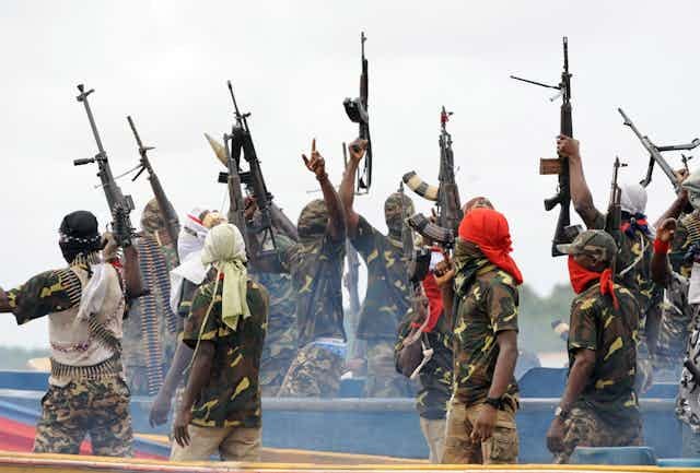 Men waving their rifles in the air in celebration Men waving their rifles in the air in celebration