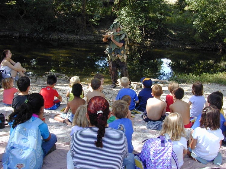 A group of children sitting on the ground

AI-generated content may be incorrect.