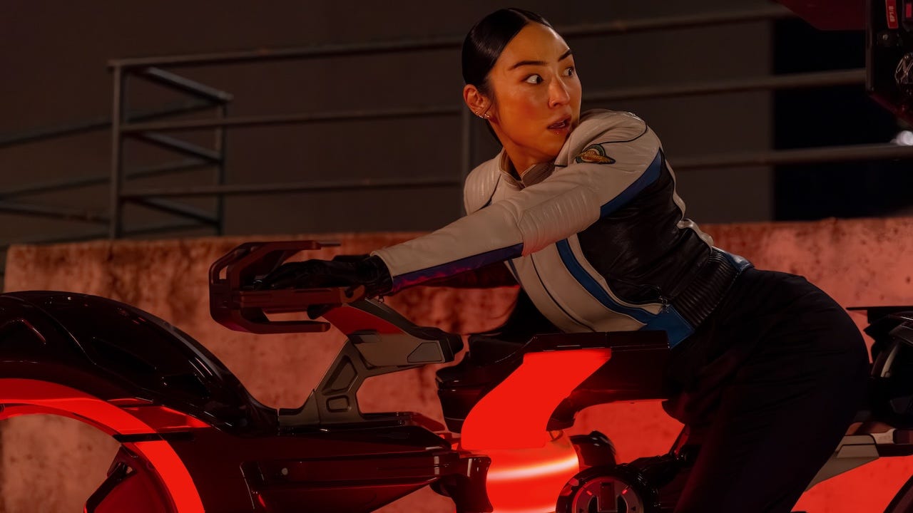 Eve (Greta Lee) looking scared while riding one of the lightcycles. Eve (Greta Lee) looking scared while riding one of the lightcycles.