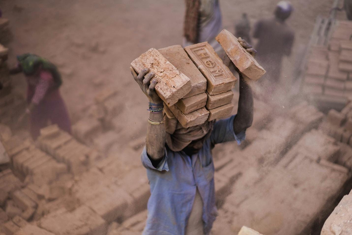 A person carrying bricks on his head
AI-generated content may be incorrect. A person carrying bricks on his head
AI-generated content may be incorrect.