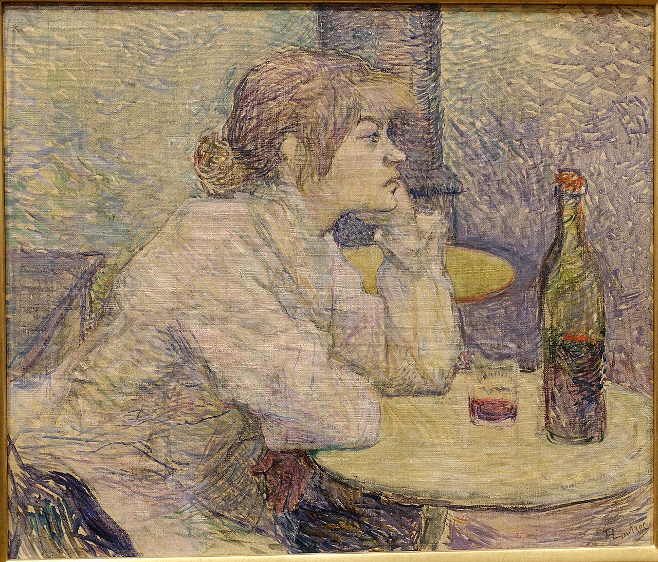 A woman alone at a cafe table with a bottle and half empty glass