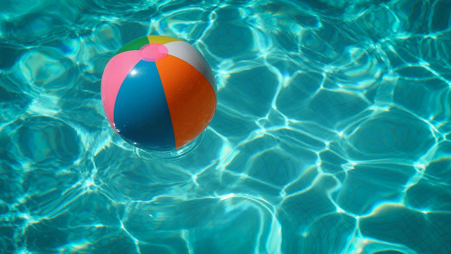 A beach ball floating on blue water