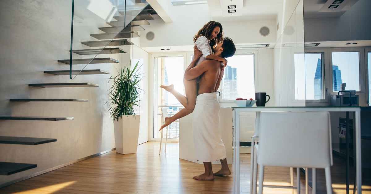Man lifting woman up, both are happy and smiling