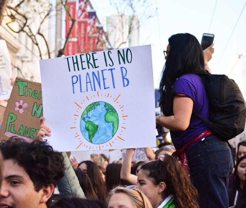 person holding there is no planet b poster