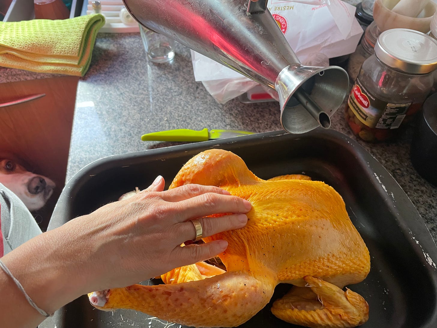 Untando el pollo con el AOVE bajo la atenta mirada del ayudante