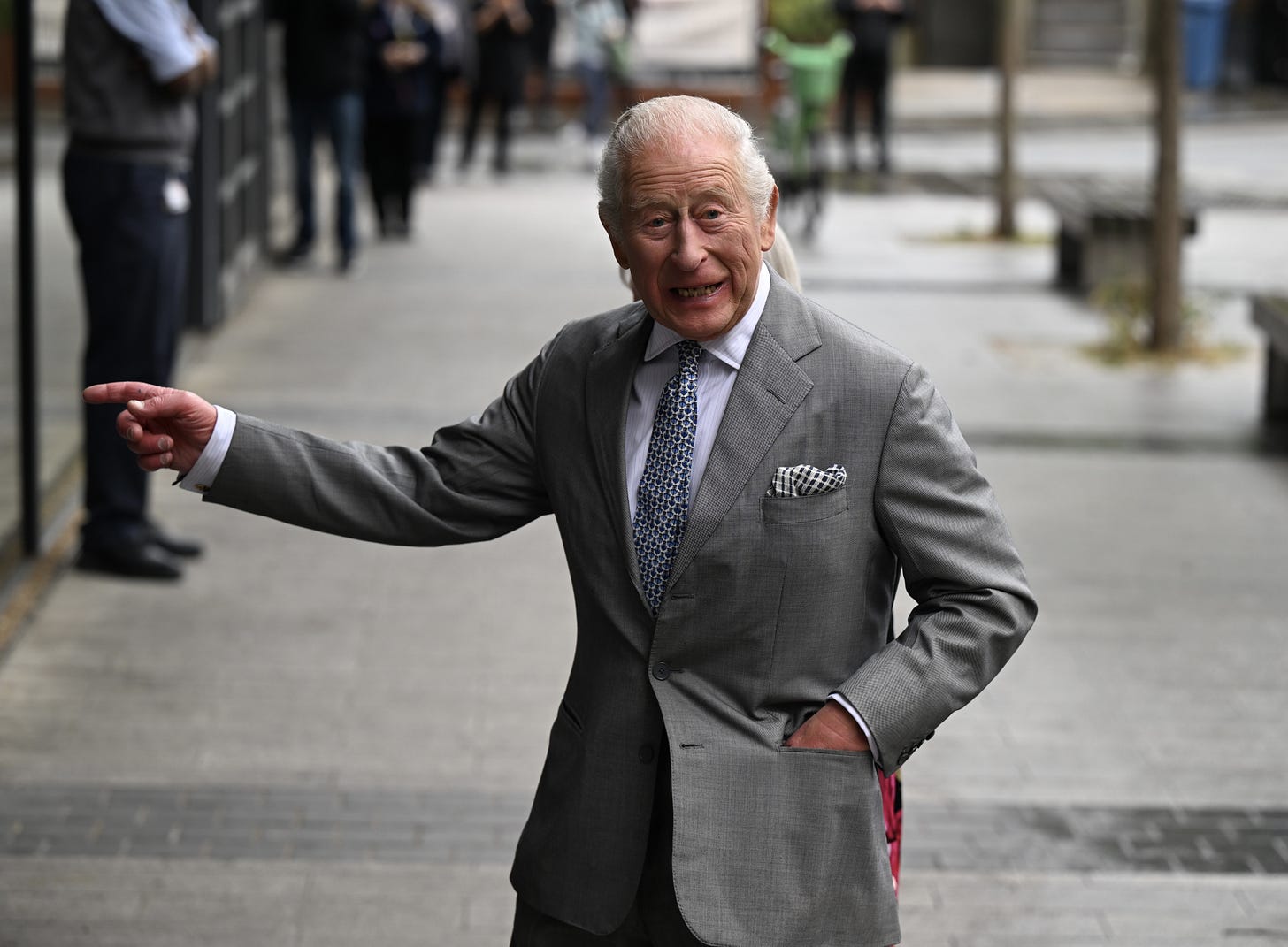 King Charles smiling in a grey suit