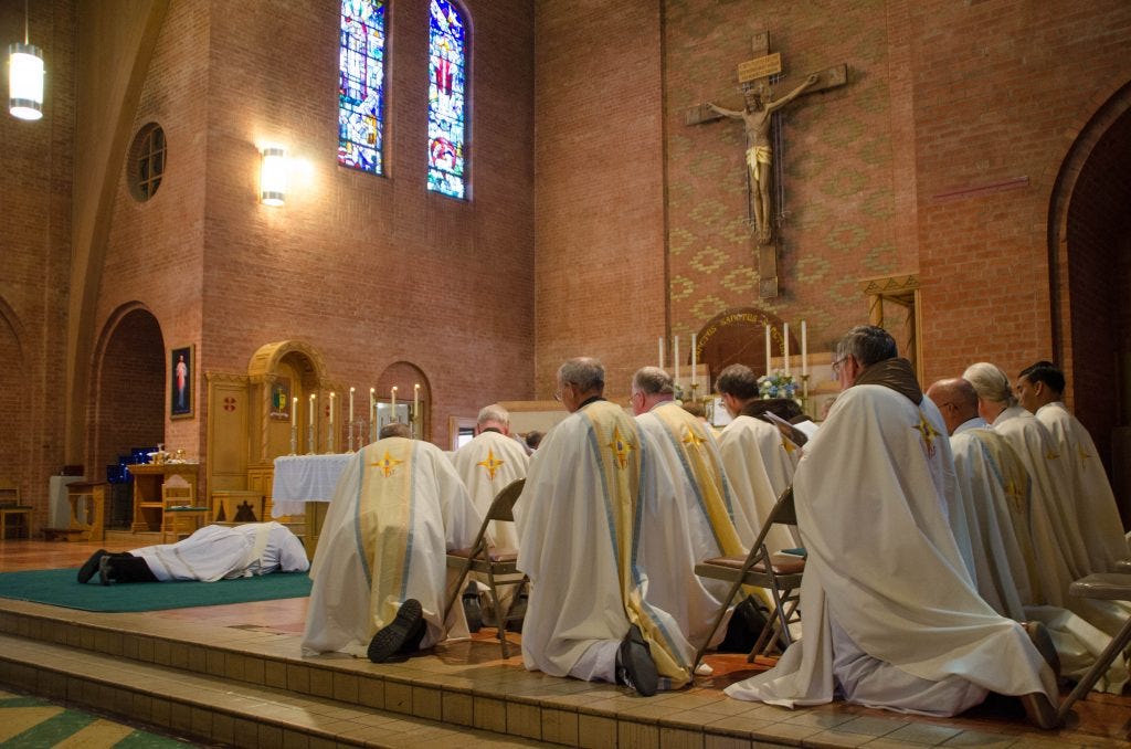 Diocesan priests pray the Litany of Saints as Robert Badger prostrates himself. Diocesan priests pray the Litany of Saints as Robert Badger prostrates himself.