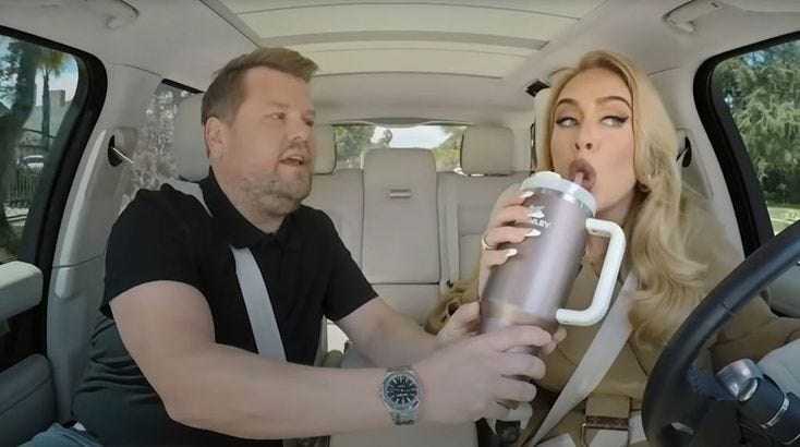 This may contain: a man and woman sitting in the back seat of a car drinking from mugs