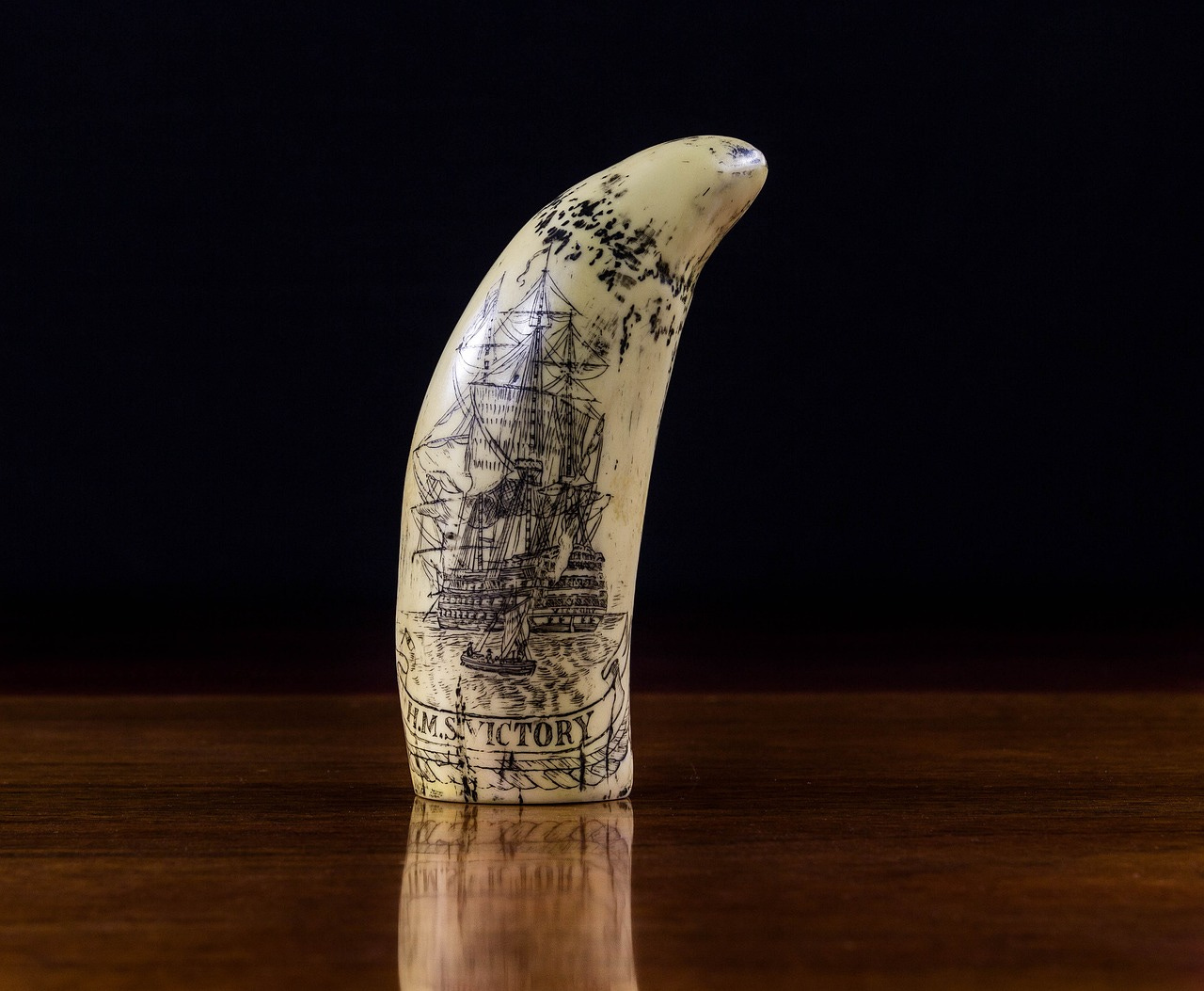 Image of a scrimshaw depicting a sailing ship with a black background Image of a scrimshaw depicting a sailing ship with a black background