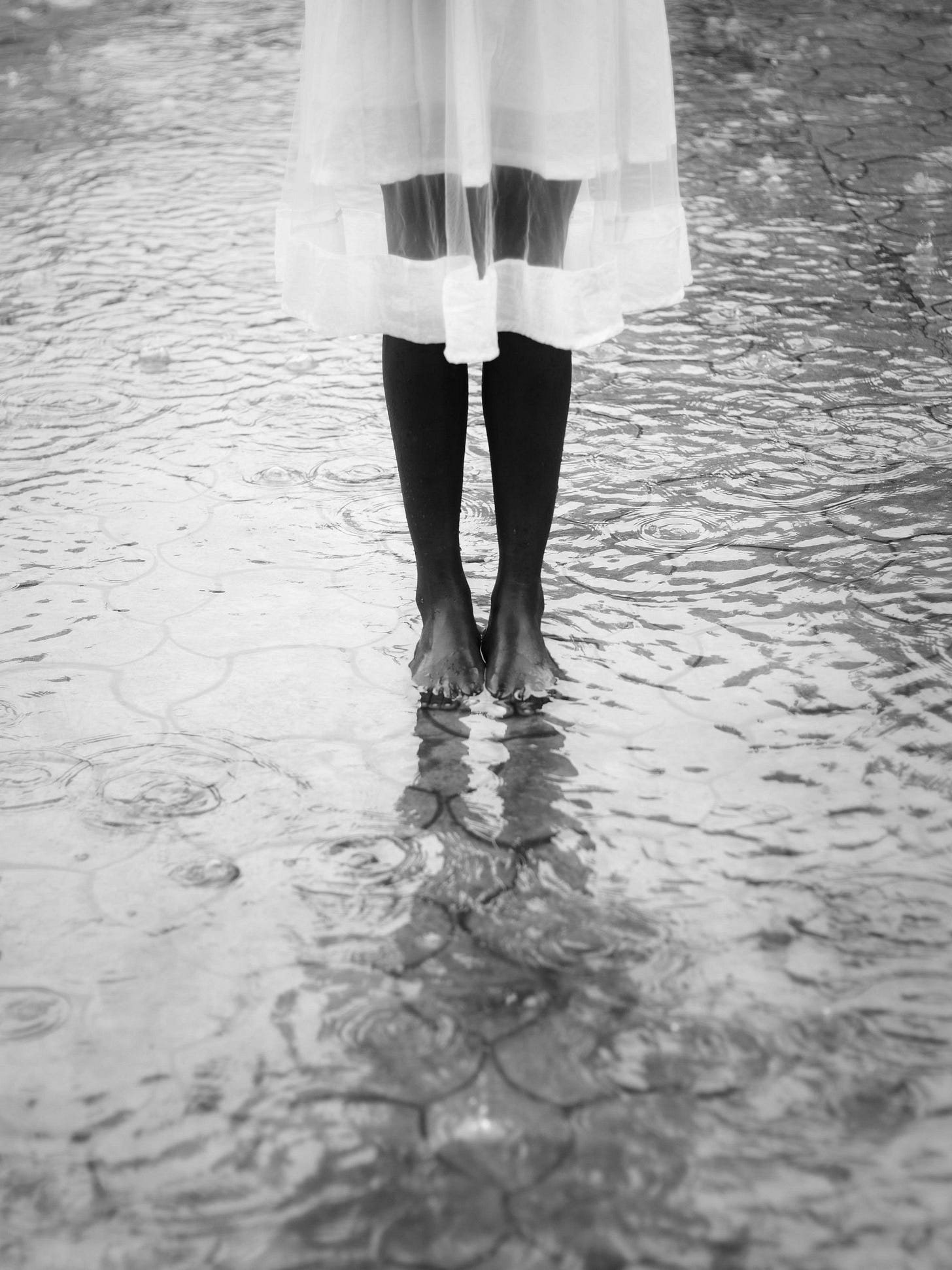 A barefoot woman standing in still water, evoking emotional clarity, the calm after choosing herself, and the quiet strength of honoring personal boundaries.