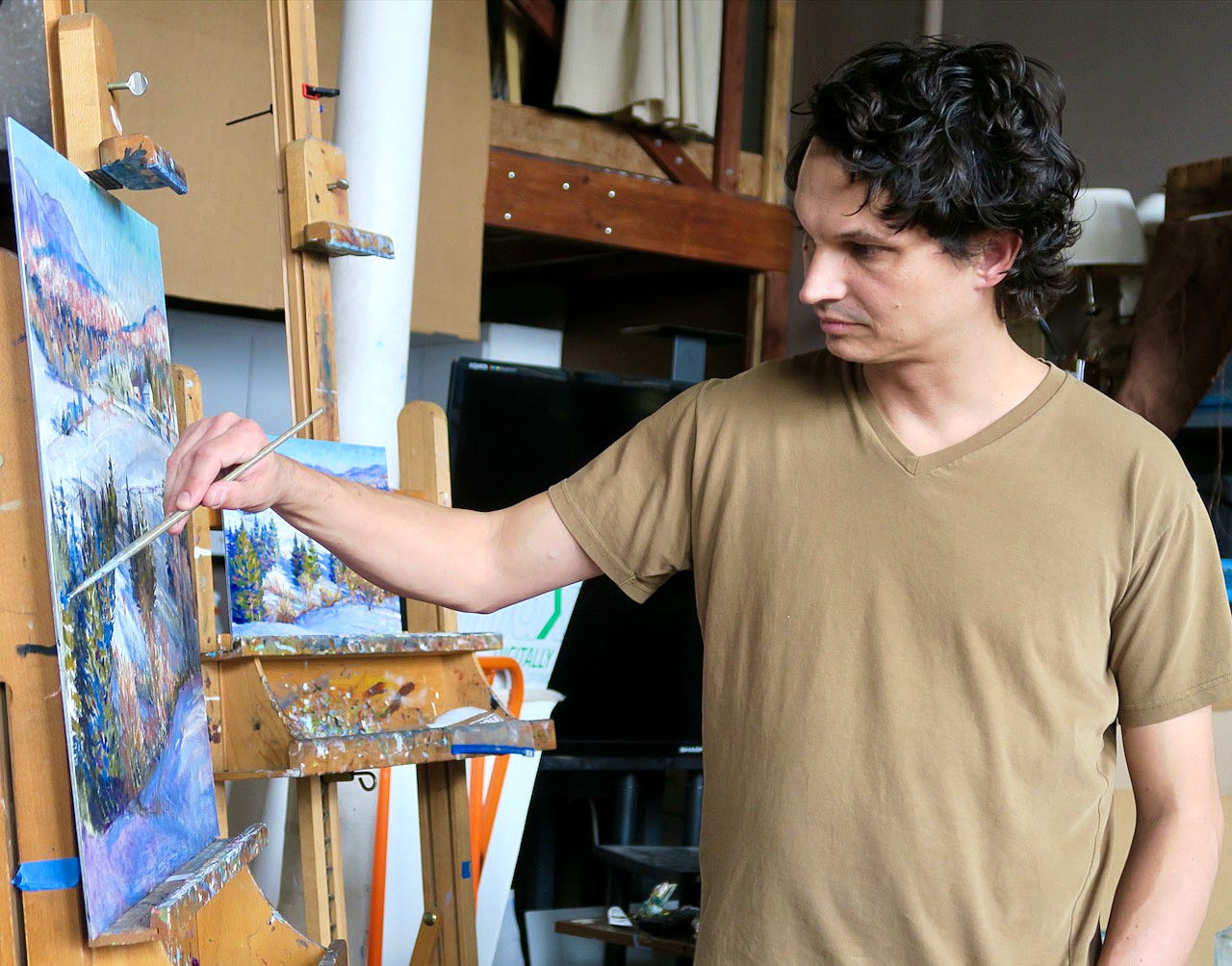 A person painting on a canvas

Description automatically generated