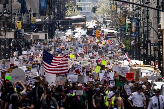Wide shot of thousands holding signs at protests