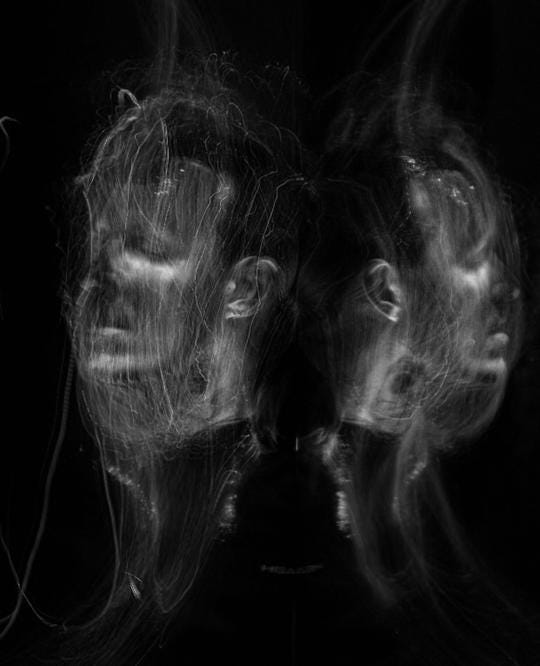 Abstract light painting of two mirrored faces