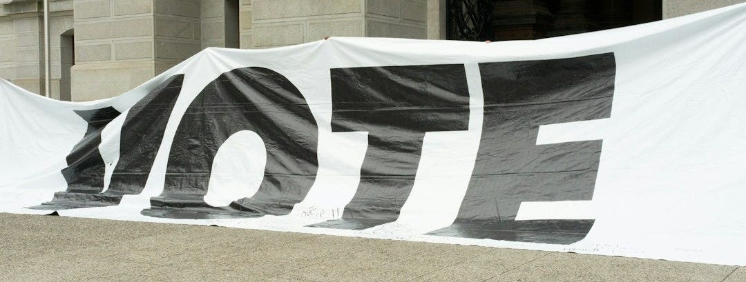 A large sign that says vote on it