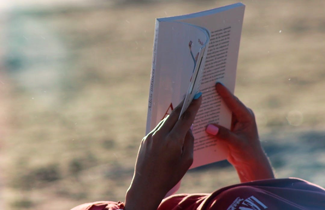 person holding white book during daytime