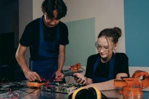 woman and man by table with electronics woman and man by table with electronics