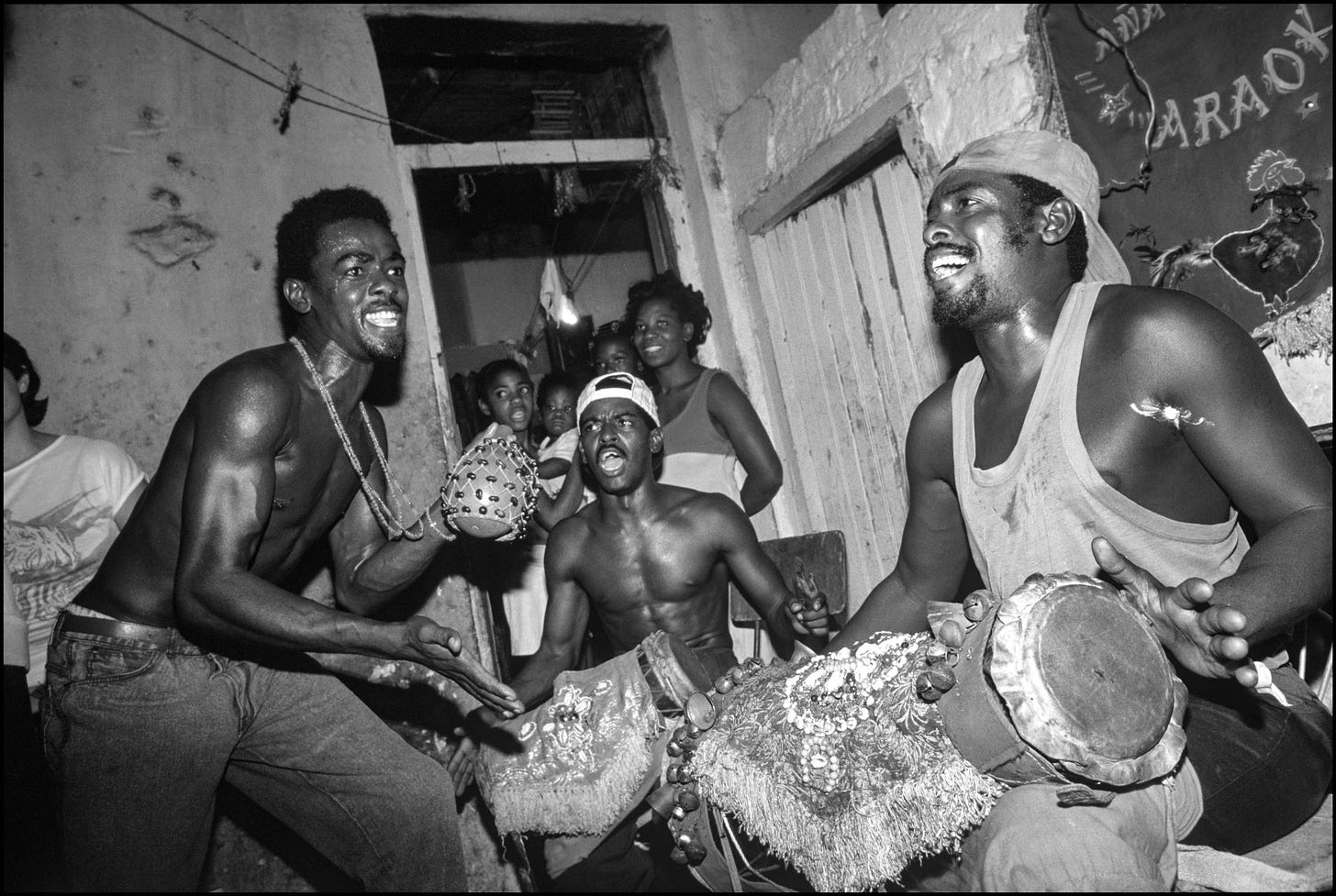 A group of men laughing and holding drums

Description automatically generated