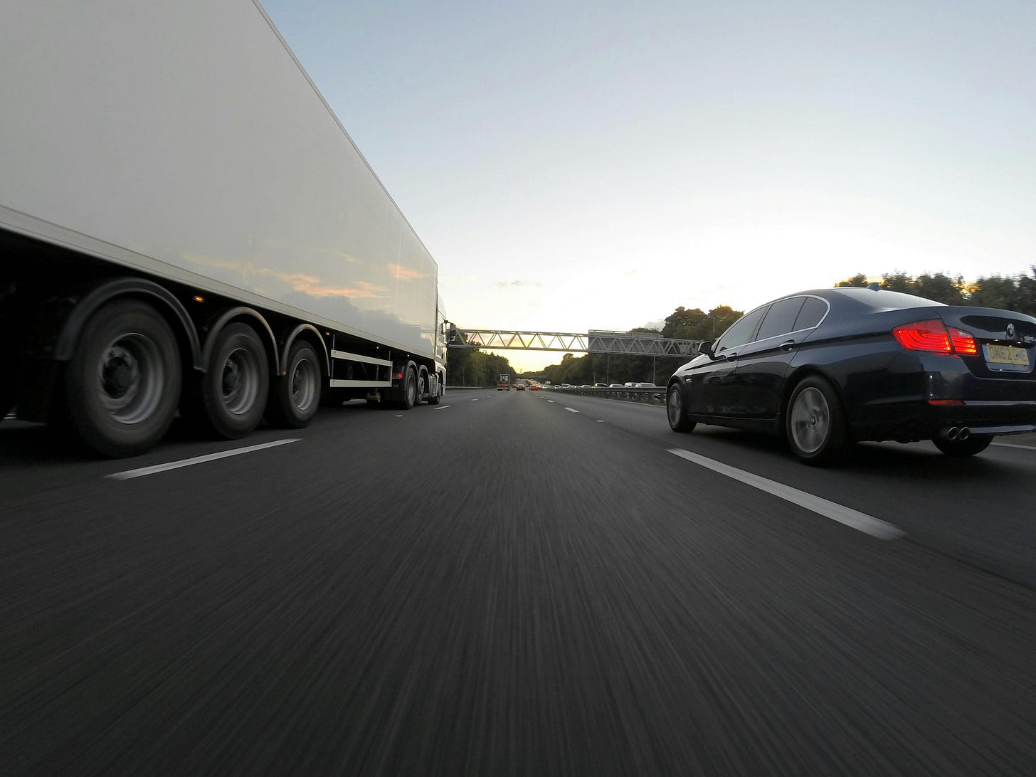 A semi-truck and a sports car side-by-side. 