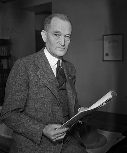 A person in a suit holding a paper

AI-generated content may be incorrect.