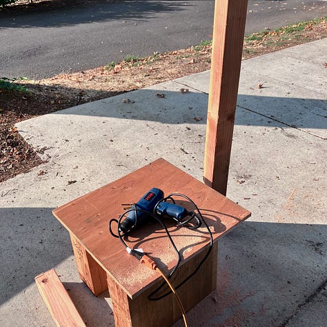 Steps to build a little library, digging a hole, pouring cement, sawing the wood, priming and painting, filling with books