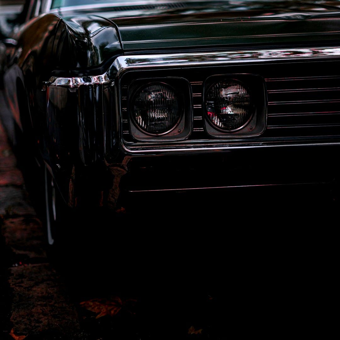 a black car parked on the side of the road a black car parked on the side of the road