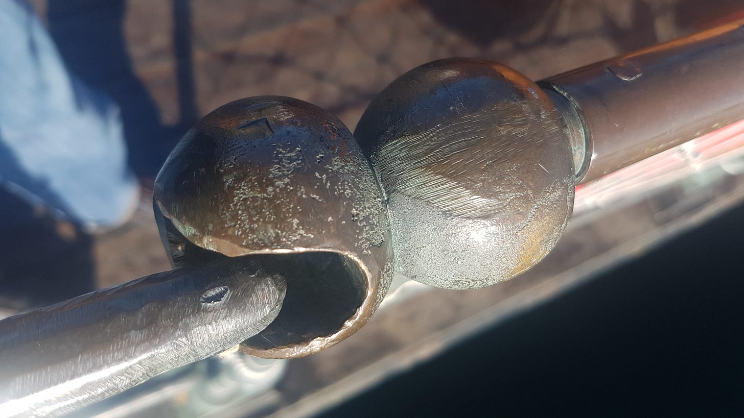 Close-up of a metal hand rail fitting on an old boat taken from above. 