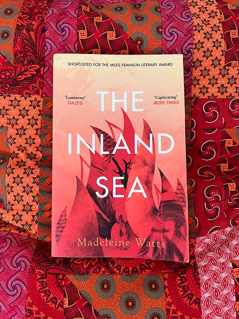 Three novels with colourful covers, set against backdrops of similar colours.