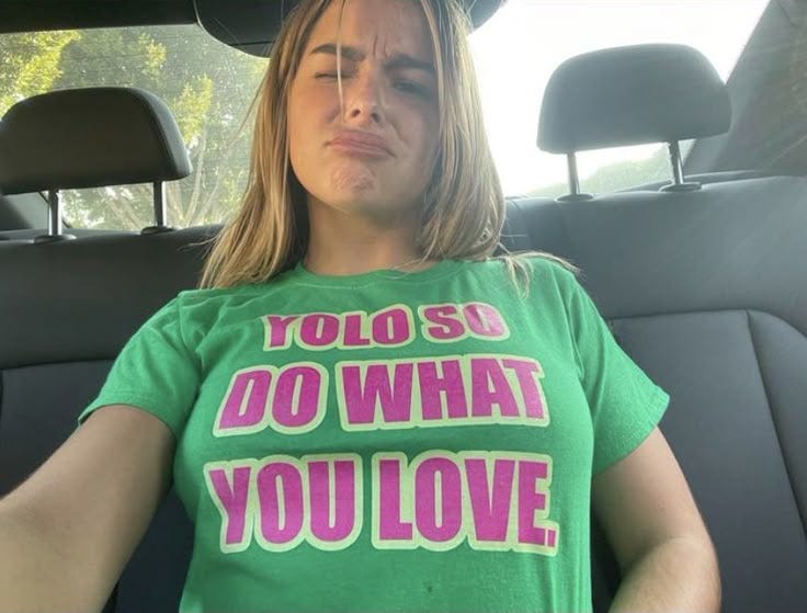 This may contain: a woman sitting in the back seat of a car with her hands on her hips