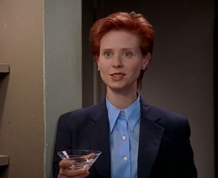 This may contain: the woman is holding a martini glass in her right hand and looking at the camera