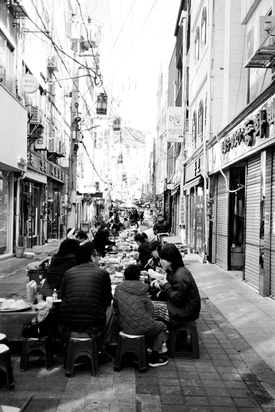 People are eating street food in a narrow alley. People are eating street food in a narrow alley.