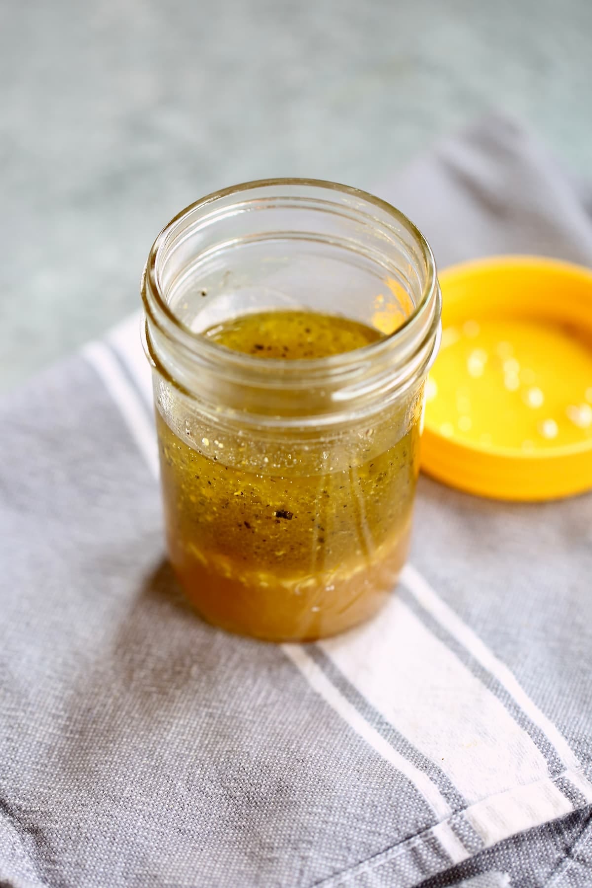 a small ball glass jar with vinaigrette in it.