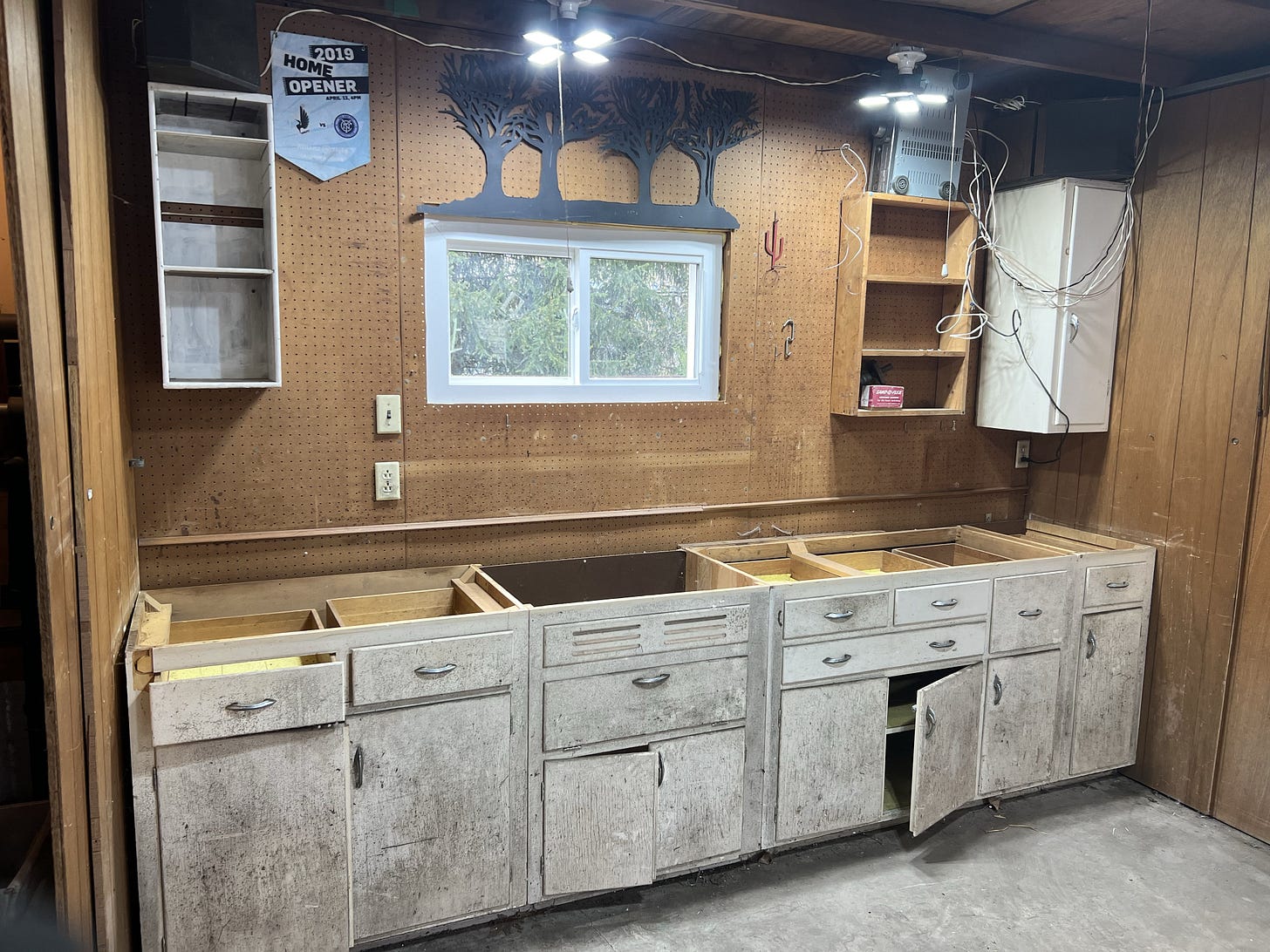 old white mildewed cabinets inside a paneled garage