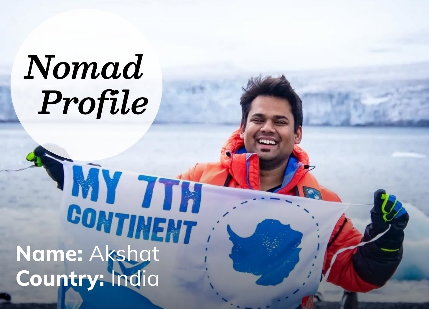 Dark-haired, light-skinned Indian man is smiling and holding up a blue and white banner that reads: My 7th Continent.” He is wearing an orange parka and standing outside in the snow and ice.