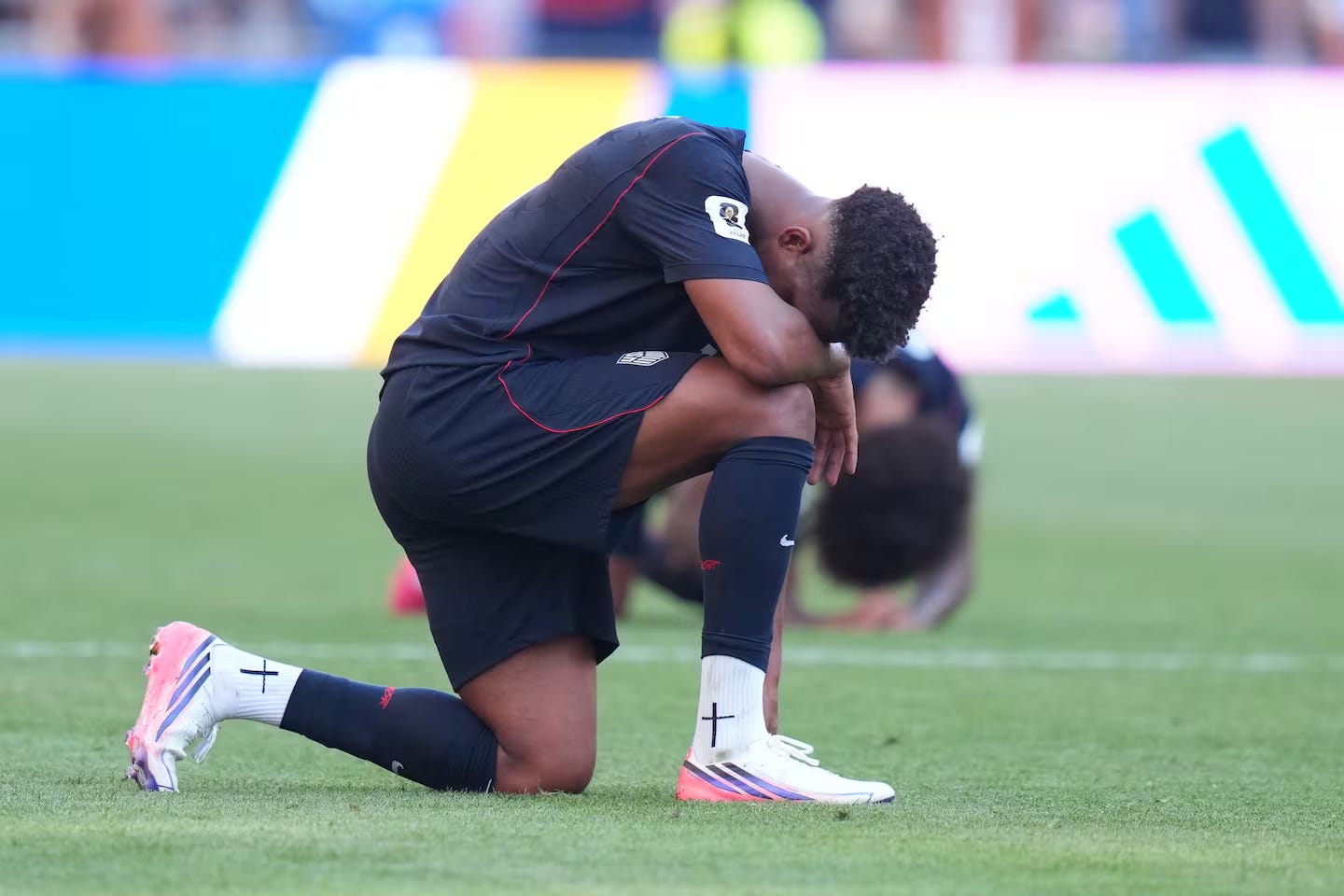 A football player kneeling on the ground

AI-generated content may be incorrect.