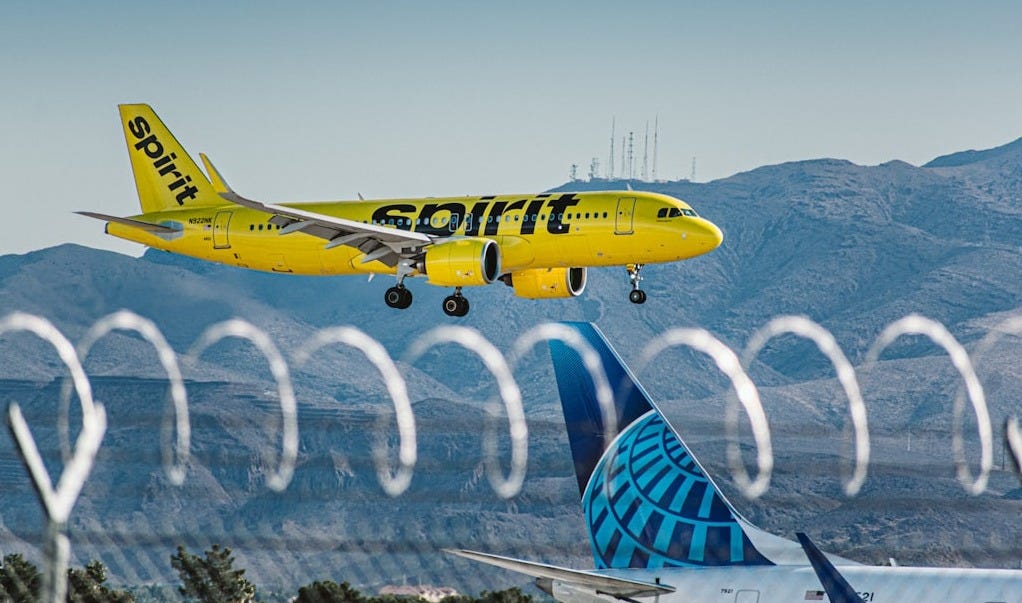 a yellow and blue jet airliner taking off from an airport