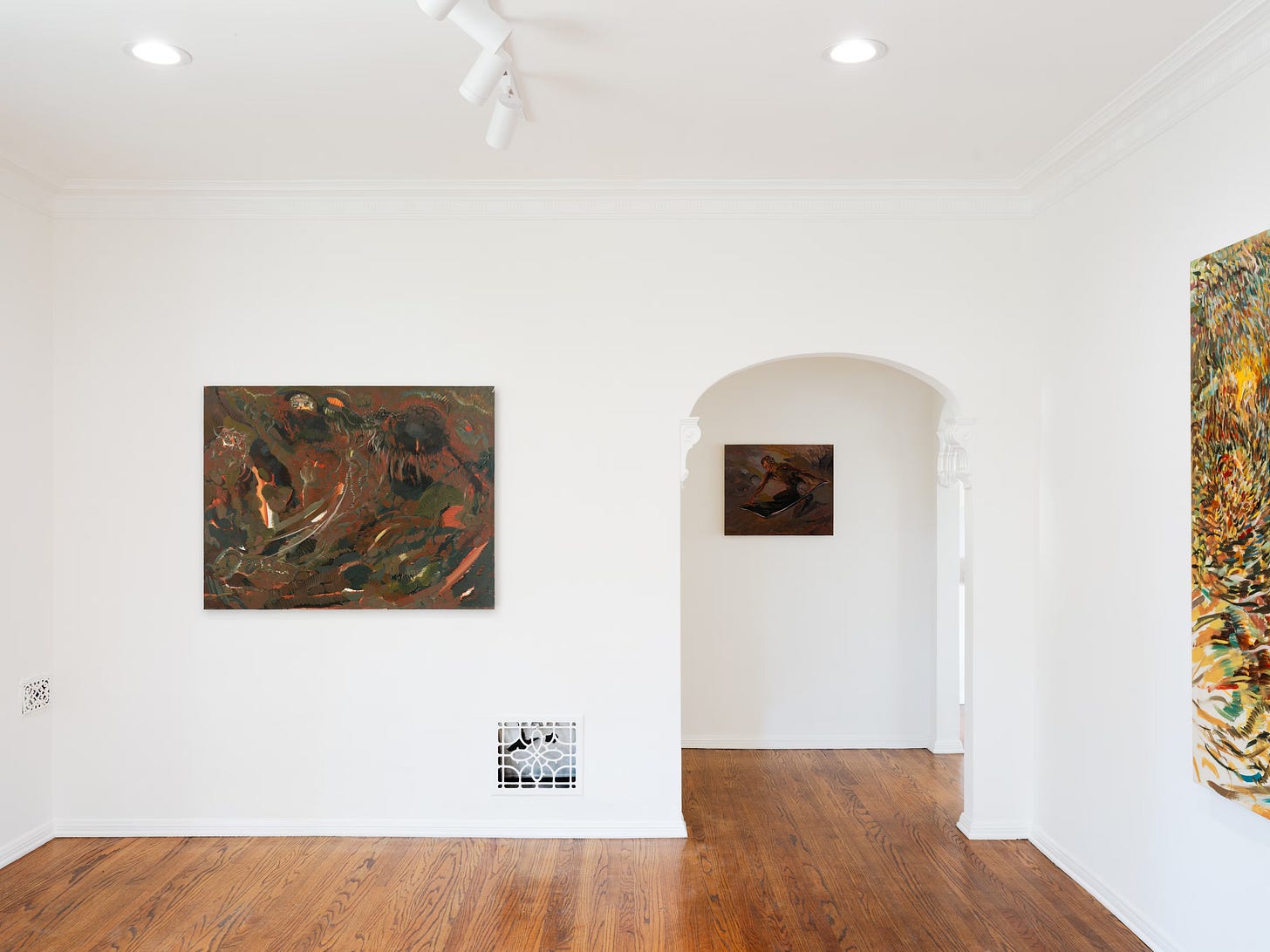 White gallery room with arched niche and three paintings from Talking to the Moon installed on the walls