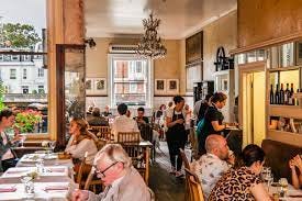 A group of people sitting at tables in a restaurant

Description automatically generated