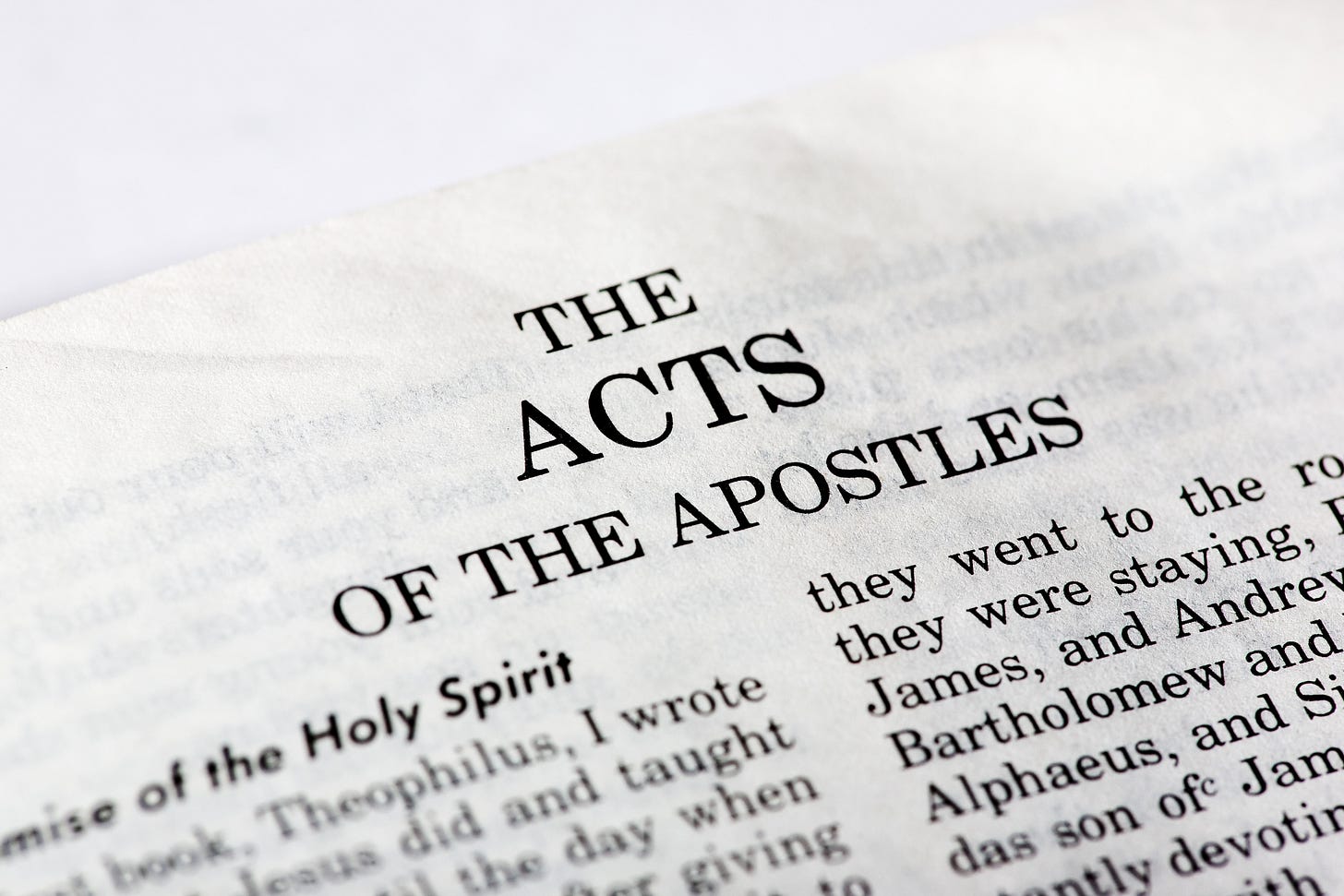 A photograph of the first page from The Acts of the Apostles in a Bible.